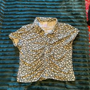 Stretchy, soft material, green with white floral, brown buttons down the front.